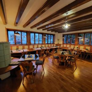 布伦茨河畔金根Brauereigasthof Schlüsselkeller的餐厅设有木桌、椅子和窗户。