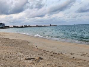 瓜拉丁加奴Triple H Minionstay Kuala Terengganu的阴天与大海的沙滩