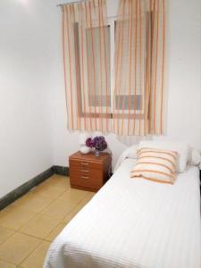 布埃乌4 bedrooms appartement at Bueu的卧室配有白色的床和窗户。