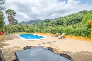 奥亨3 bedrooms villa with private pool enclosed garden and wifi at Ojen的一个带桌椅的庭院和一个游泳池