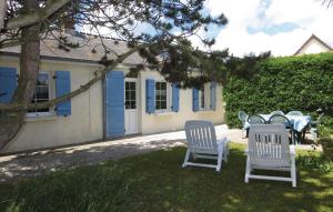 Quinéville哈马奥西蒙度假屋的房子前面的一张桌子和椅子