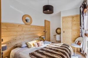 孔布卢La Suite Édelweiss - Welkeys的一间卧室配有一张木墙床