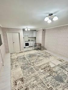 TürkistanЭлитная новая квартира в Туркестане 2的地板上有一个大地毯的空客厅