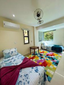 曼加拉蒂巴Apartamento LUXO no Porto Real Resort ao lado da praia的一间卧室配有床和色彩缤纷的地毯。