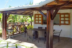 马埃堡4 bedrooms villa with private pool enclosed garden and wifi at Mahebourg 1 km away from the beach的凉亭下带桌椅的天井