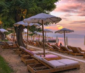 卡诺尼Vasiliki Little House的海滩上的一组躺椅和遮阳伞
