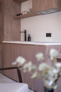 普里什蒂纳Bloom Suites的厨房配有木制橱柜和玻璃桌