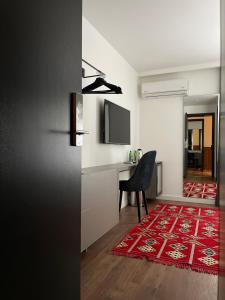 普里什蒂纳Etnomania Boutique Hotel的一间设有桌子和椅子的房间,并铺有红色地毯。