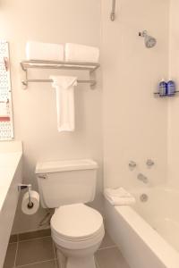 斯诺马斯村怀尔德伍德斯诺马斯酒店的白色的浴室设有卫生间和浴缸。