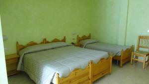 圣贾科莫Albergo Nazionale的一间卧室配有两张单人床和一把椅子