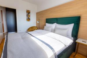 泰斯利奇Platinum_Luxury_Apartment的一间卧室配有一张大床和绿色床头板