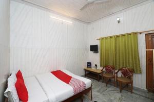 乌德尔格希Geetanjali Resort的卧室配有一张床和一张桌子及椅子