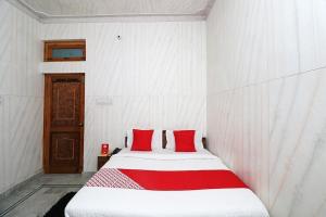 乌德尔格希Geetanjali Resort的客房内的白色床和红色枕头