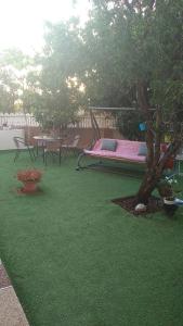 提比里亚LTD Hadas Garden apartment的庭院内一个带吊床和树的游乐场