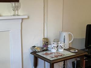 大莫尔文吉尔伯特之末农场酒店的一张小桌子,上面有杯子和花瓶