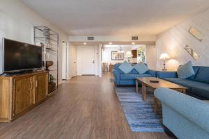 棕榈泉Casitas del Monte的客厅配有蓝色的家具和平面电视。