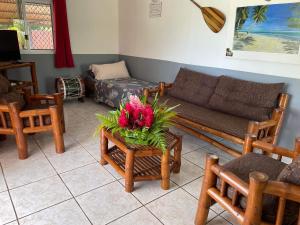 FaieChez Here - Ata的客厅配有沙发和鲜花桌
