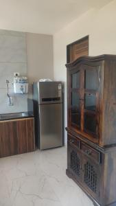 门格洛尔Manasvi的厨房配有木制橱柜和冰箱。