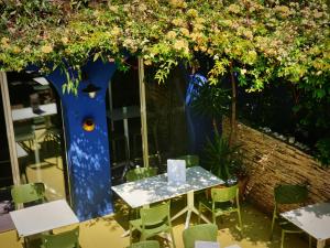 巴斯蒂亚Sud Hôtel Restaurant的树下种满鲜花的桌子和椅子