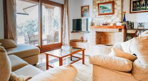 巴利-略夫雷加Cal Nano Casa Rural的客厅设有两张沙发和一个壁炉