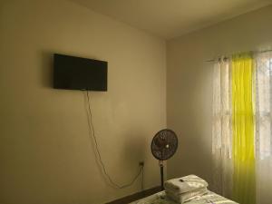 特古西加尔巴Hospedaje Casa de Luna的客房设有壁挂式电视和风扇。