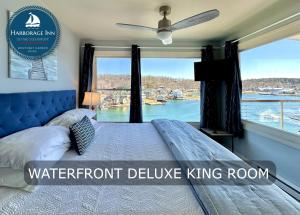 布斯贝港Harborage Inn on the Oceanfront的一间卧室设有一张大床和大窗户