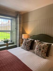 阿尔恩茅斯The Red Lion Inn Alnmouth的卧室配有带枕头的床铺和窗户。