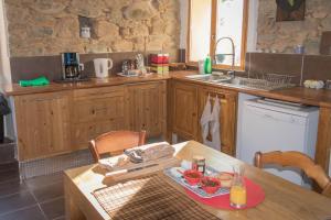 卡伦扎纳a Casa的厨房配有木制橱柜和一张带食物的桌子。