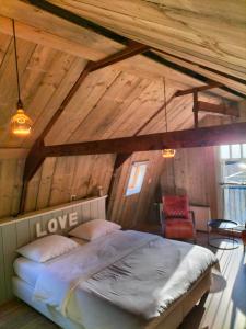 Sint PancrasDe oude walnoot的木制阁楼卧室配有一张床