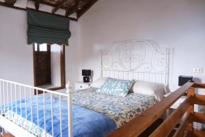 San Juan de la RamblaCasa Rural Felipe Luis的一间卧室配有一张白色的床和蓝色的毯子