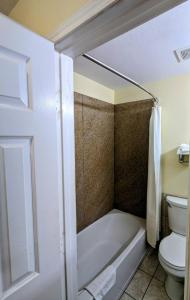 利伯蒂利伯蒂套房汽车旅馆的带浴缸和卫生间的浴室。