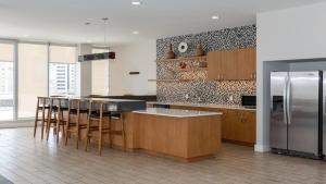 达拉斯Stunning 2BR CozySuites with roof pool, lounge gym的厨房配有木制橱柜和不锈钢冰箱。