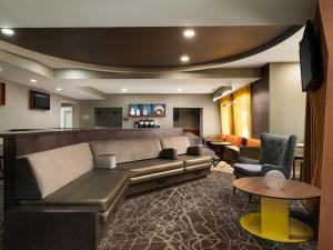 欧弗兰帕克 春季山丘套房酒店 - 堪萨斯市欧弗兰帕克的客厅配有沙发和桌子