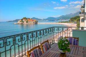 斯韦蒂·斯特凡Montesan Luxury Apartment的一个带桌椅和海滩的阳台