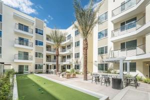 凤凰城Modern CozySuites - paradise under the palm trees!的一个带草坪和棕榈树的公寓庭院