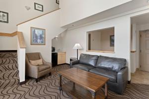桑德波因特Cedar Street Hotel & Suites的客厅配有沙发和椅子