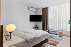 布加勒斯特One88 Apartments的一间卧室配有一张床和一台平面电视
