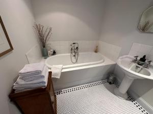 Sutton under Brailes格林希尔农场谷仓住宿加早餐旅馆的白色的浴室设有浴缸和水槽。