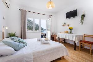 格拉达茨Apartments Nikolic的一间卧室配有一张床、一张桌子和一个窗户。