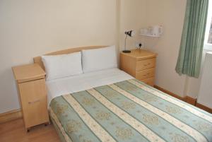 伦敦贝尔格罗夫酒店的一间卧室配有一张床、梳妆台和一张西德西德西德西德床。