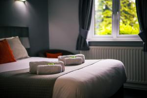 盖茨黑德鲍斯应克林酒店的一间卧室配有一张床,上面有两条毛巾