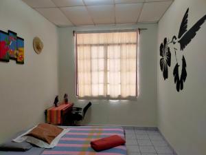 马塔加尔帕Matagalpa Tours Guest House的一间卧室设有一张床、一个窗口和一张桌子