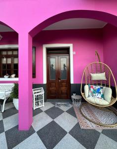 FaialResidência Mendonça的一间设有粉红色墙壁和藤椅的房间