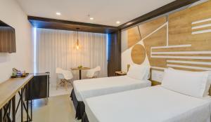 里约热内卢Rio Design Copacabana Hotel的酒店客房设有两张床和一张桌子。