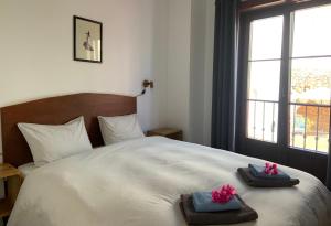 内尔哈Boutique Hostal Lorca的一间卧室配有带毛巾的床和窗户。