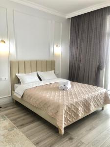 阿斯塔纳Premium Apartments Esil Riverside的卧室配有带白色枕头的大床