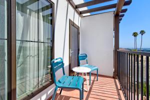 圣克鲁兹Marea Sol Hotel的阳台上配有2把蓝色椅子和一张桌子