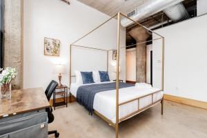 圣路易斯CozySuites Stunning 1BR Adler Loft with Parking的一间卧室配有一张天蓬床和一张书桌