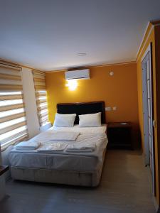 安塔利亚TAG Pansiyon的一间卧室设有一张黄色墙壁的大床