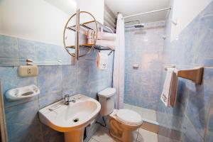 库斯科普林西比三世酒店的蓝色瓷砖浴室设有水槽和卫生间